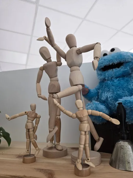 Holzfiguren in ausdrucksstarken Haltungen auf einem Tisch – Aufstellungsarbeit in der Praxis